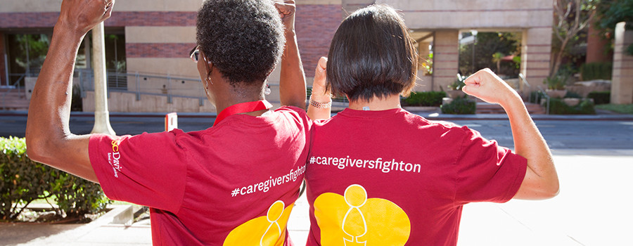 Picture of two woman wearing FCSC t-shirts and flexing with the words "Caregivers Fight On"