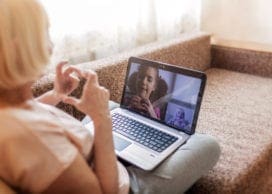 Cute girl talking with her grandmother within video chat on laptop, life in quarantine time