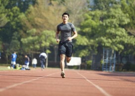 young asian man male athlete running training exercising on track