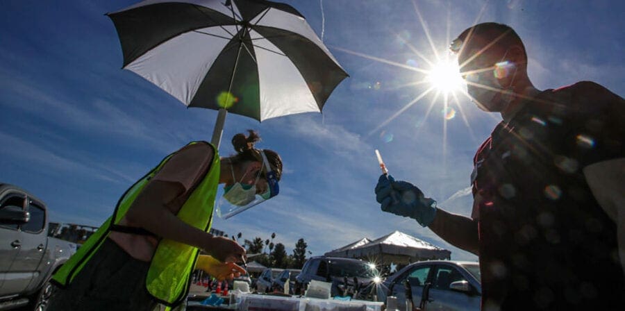 Richard Dang, right, of the USC School of Pharmacy prepares a COVID-19 vaccine during a mass-vaccination event at Dodger Stadium. (Photo/Irfan Khan, Los Angeles Times via Getty Images)