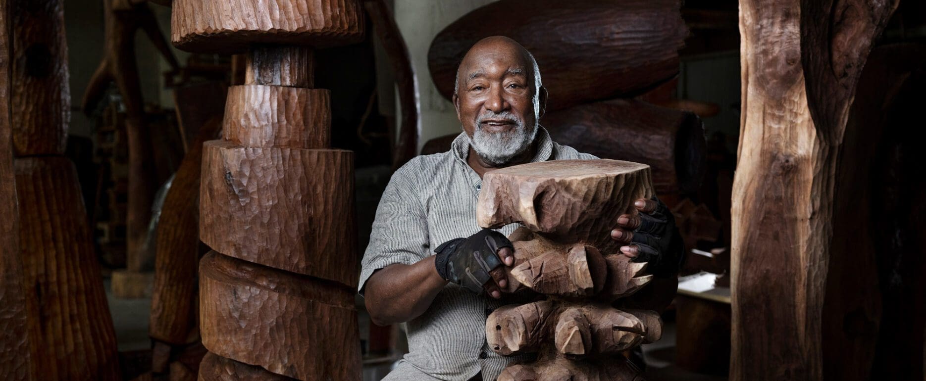 Thad Mosley holding his wooden sculpture in his art studio
