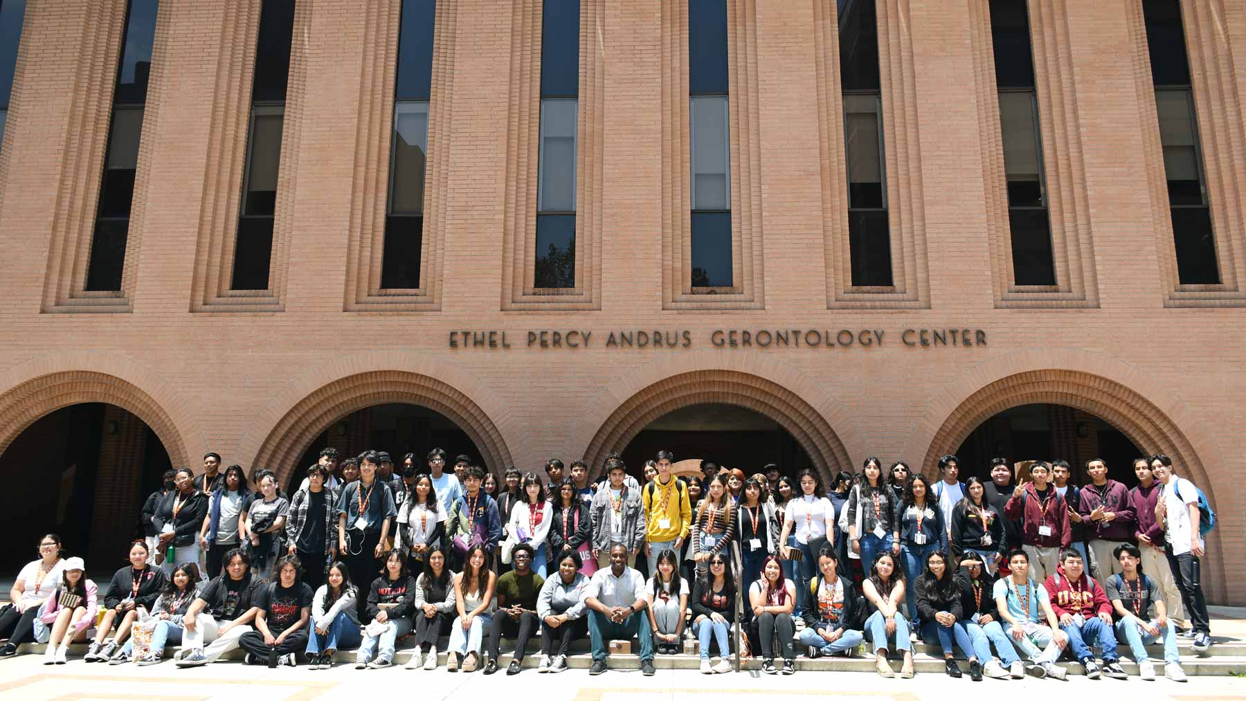 Group of students sitting and standing in front of the USC Leonard Davis School