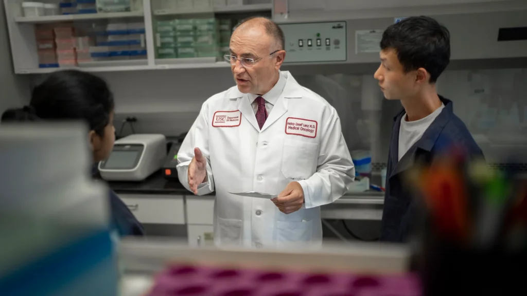 Heinz-Josef Lenz, center, talks with postdoctoral scholar Pooja Mittal, left, and research technician Jae Ho Lo. (Photo/Chris Shinn)
